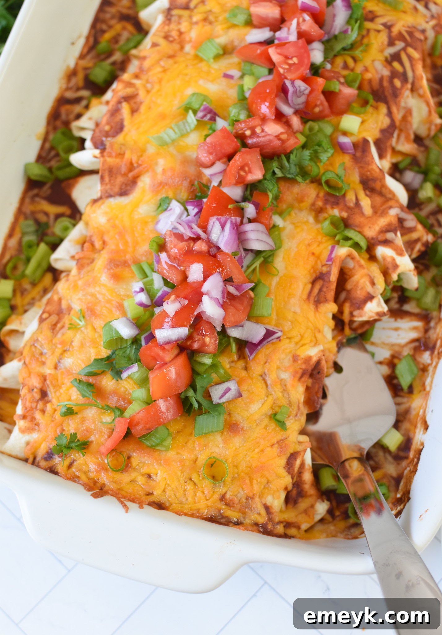 Homestyle Beef Enchiladas 2 Hearty Beef Enchiladas in a baking dish, fresh from the oven, with melted cheese and a golden crust.