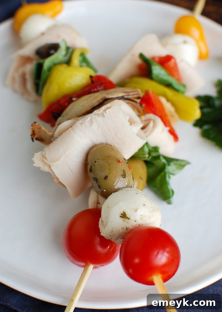 Sunny Mediterranean Skewers 6 Two Mediterranean Antipasto Skewers showcasing rolled turkey, olives, cherry tomatoes, and mozzarella balls