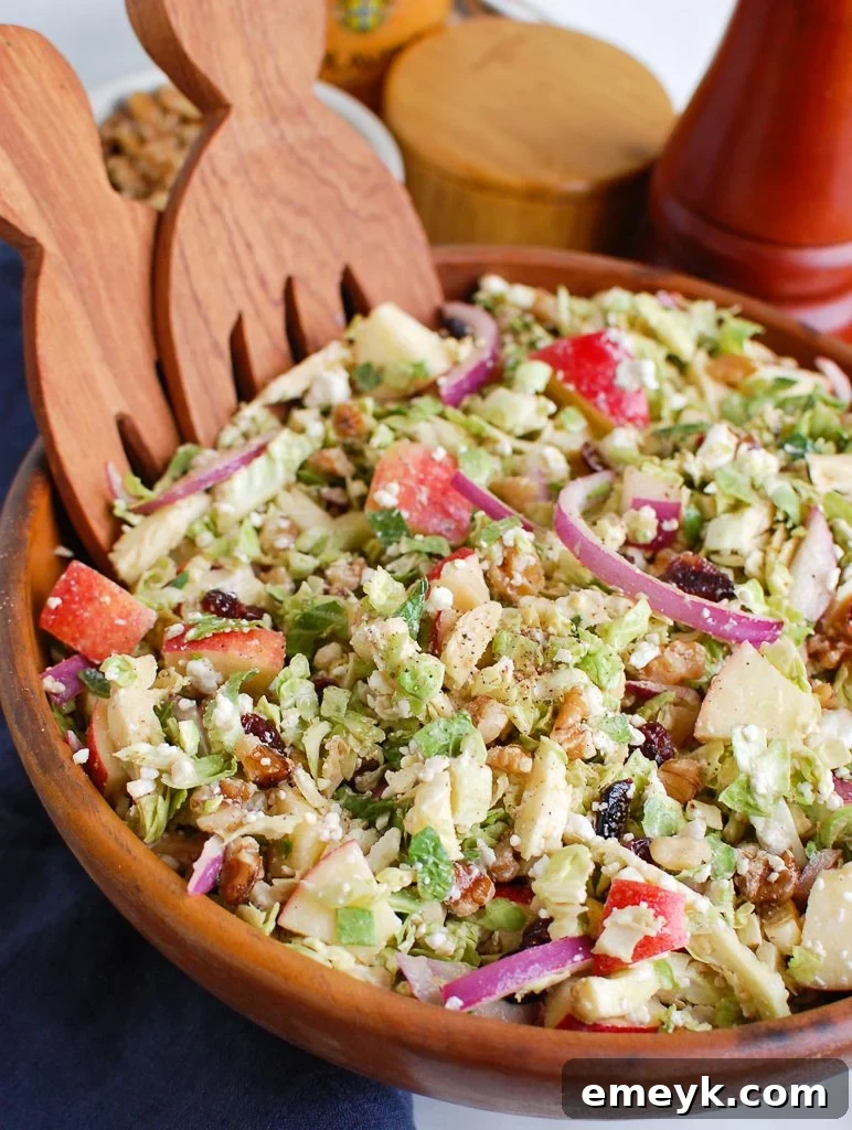 Shaved Brussels Sprout and Apple Salad with Creamy Goat Cheese 2 Brussels Sprout Apple Goat Cheese Salad in a wooden bowl, showcasing its vibrant ingredients
