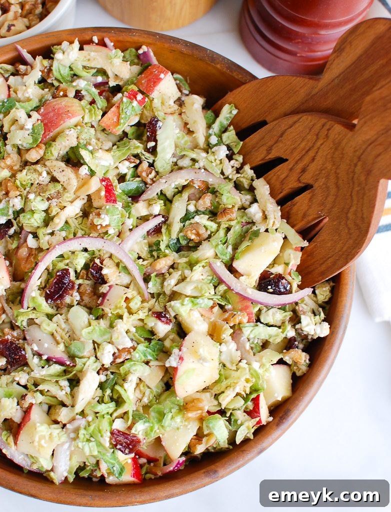 Shaved Brussels Sprout and Apple Salad with Creamy Goat Cheese 4 Brussels Sprout Apple Goat Cheese Salad served with wooden tongs, ready to be enjoyed