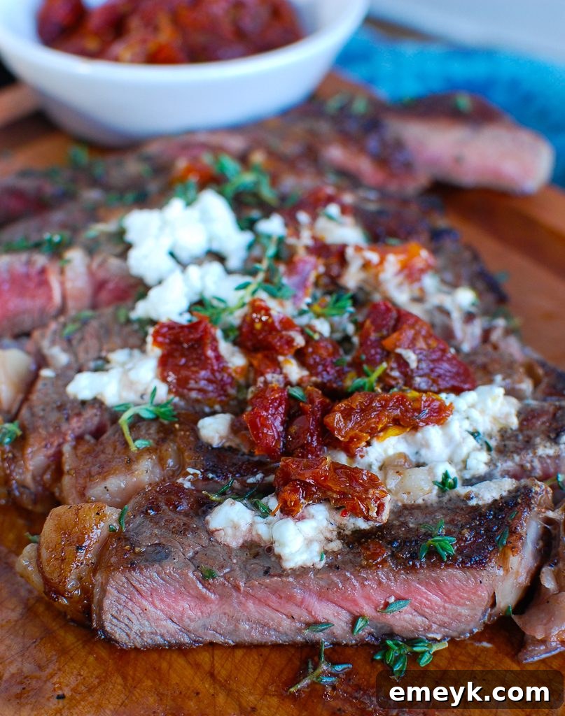 Pan-Seared Ribeye with Goat Cheese and Sun-dried Tomatoes Cut on Board 