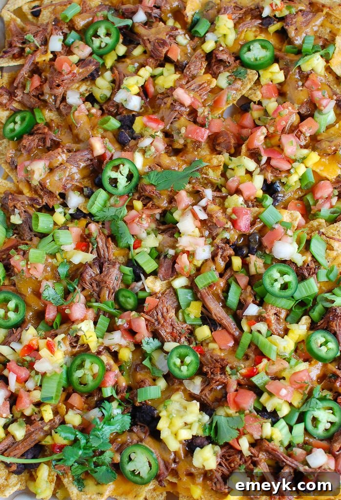 Sheet pan of Beef Nachos coming out of the oven, cheese melted perfectly