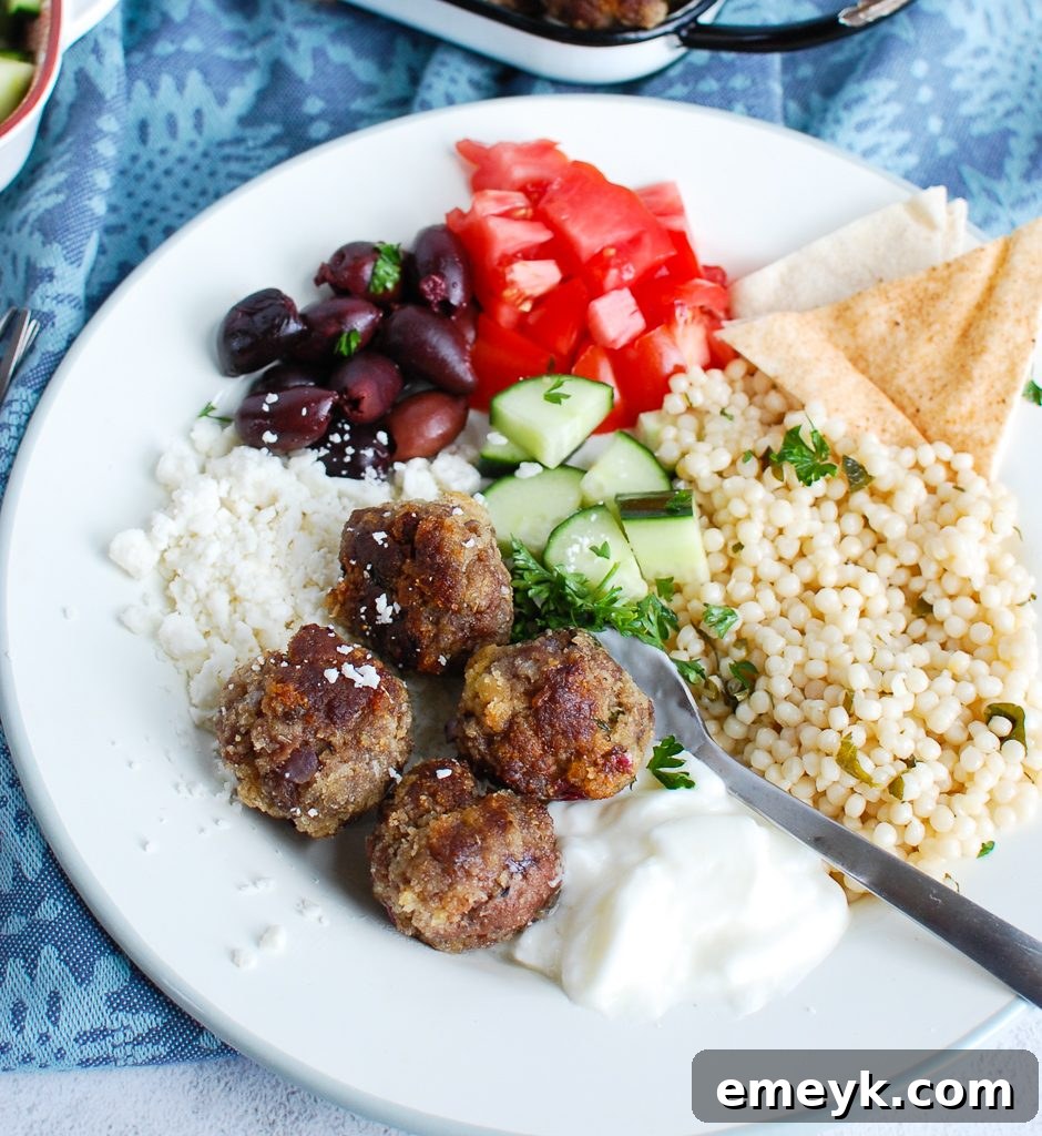 Greek Meatballs served with warm pita bread and a side of fresh vegetables, ready to be enjoyed.