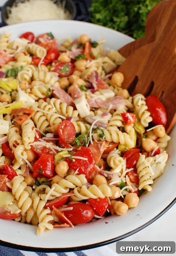 Side view of a large serving bowl filled with Italian Pasta Salad, showing the rich blend of ingredients.