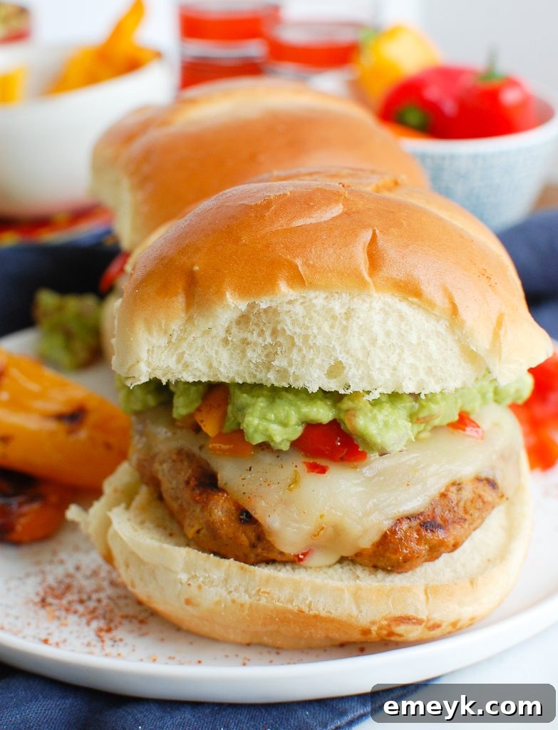 Pork Burgers with Guacamole, topped with grilled peppers on a bun