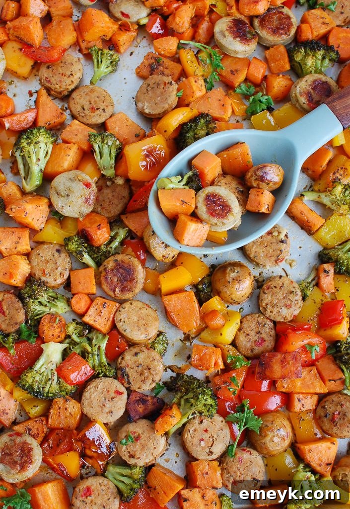 One-Pan Roasted Chicken Sausage and Vegetables 7 A portion of Sheet Pan Chicken Sausage and Vegetables with a serving spoon, highlighting the roasted texture.