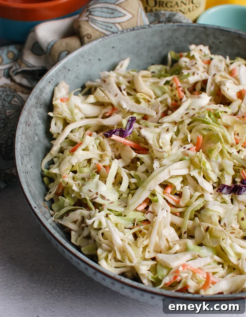 Creamy Coleslaw Recipe in a rustic blue bowl, with ingredients in the background