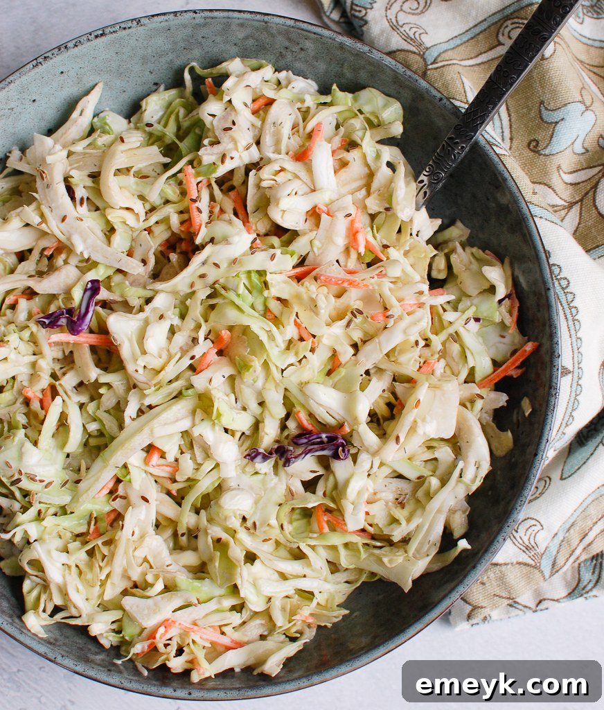 Creamy Coleslaw Recipe with a blue bowl and a serving spoon