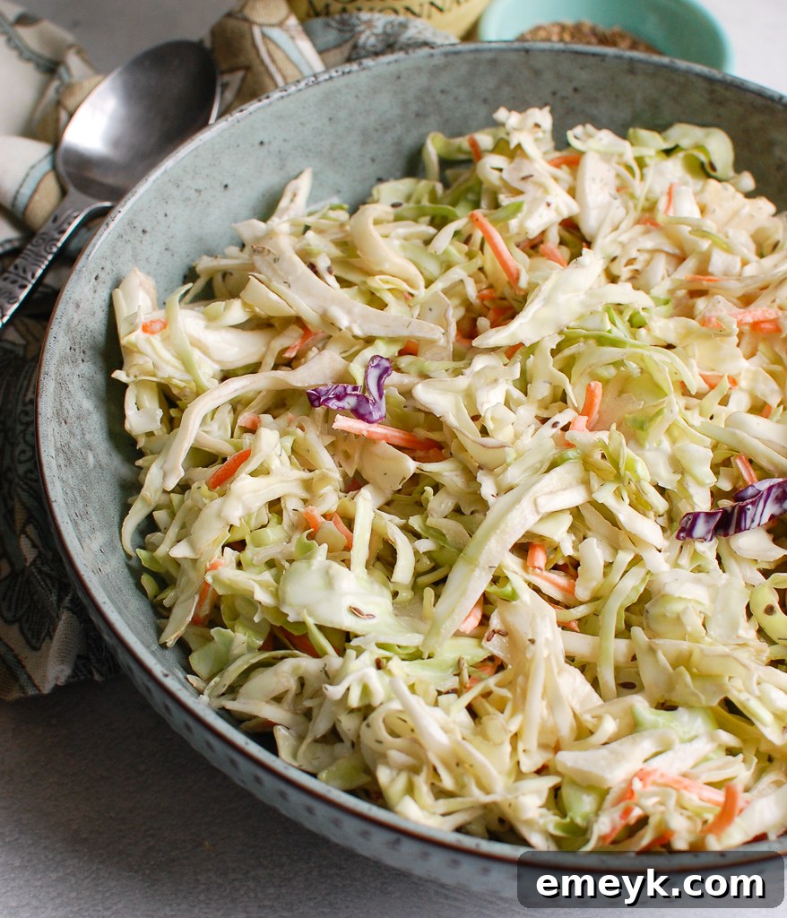 Creamy Coleslaw Recipe in a blue bowl, garnished with fresh herbs