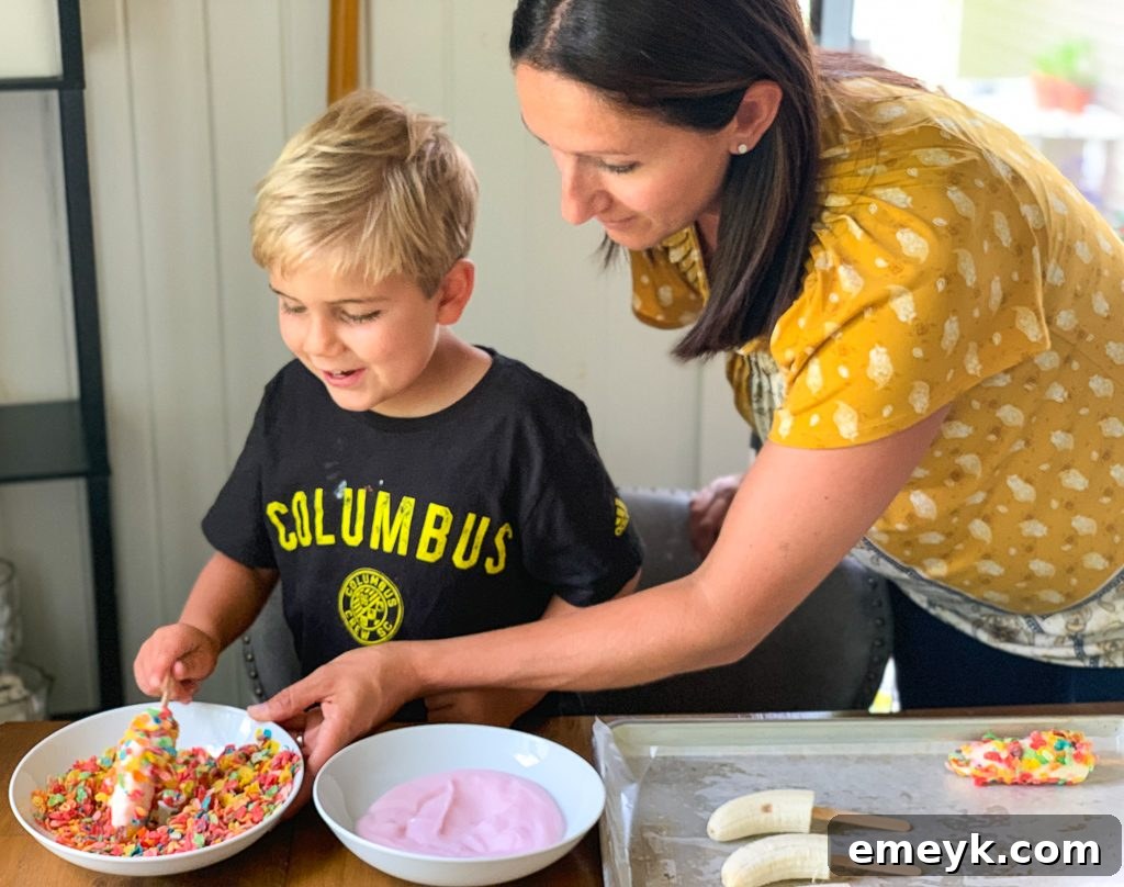 Child happily creating a Banana Crunch Popsicle, focusing on dipping
