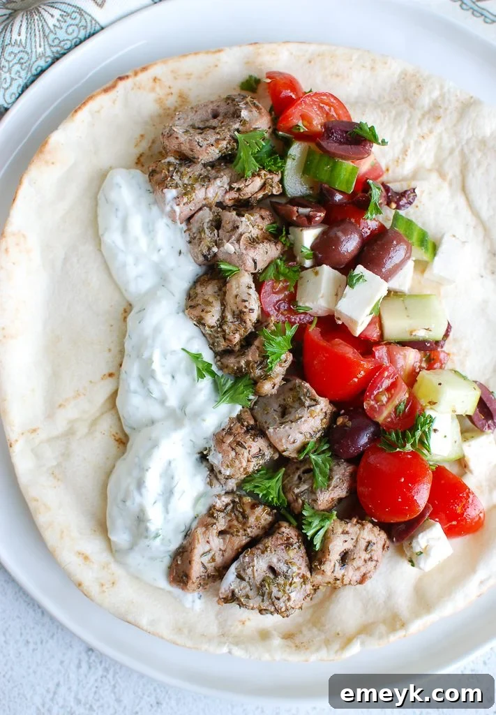 Juicy Pork Souvlaki Skewers with Zesty Tzatziki 45 Pork Souvlaki with Tzatziki on a plate, garnished with fresh herbs