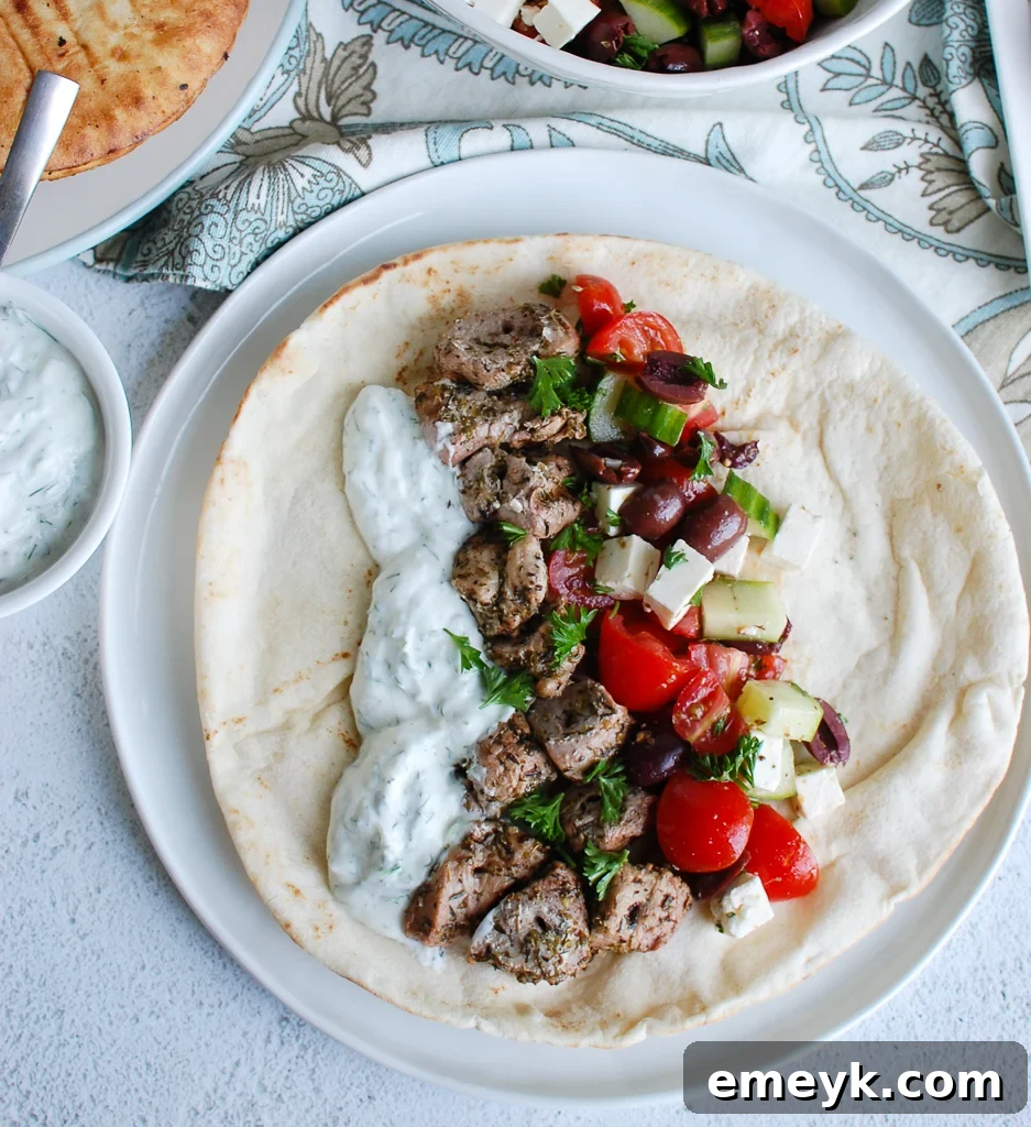 Grilled Pork Souvlaki skewers on a plate with fresh lemon wedges.