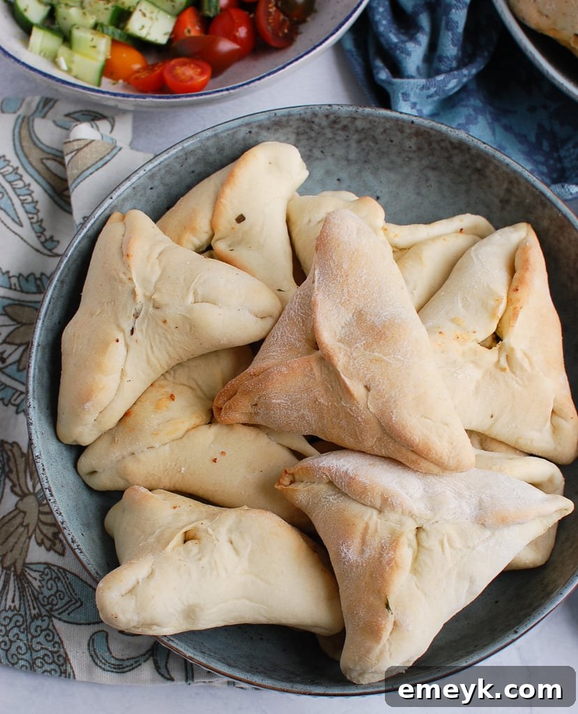 Quick Lebanese Spinach Hand Pies 2 A bowl of freshly baked golden Spinach Fatayer, triangular savory hand pies.