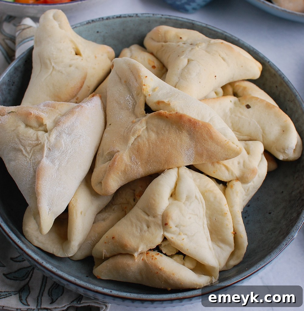 Quick Lebanese Spinach Hand Pies 4 Close-up of baked spinach fatayer, golden brown triangles with visible spinach and cheese filling.