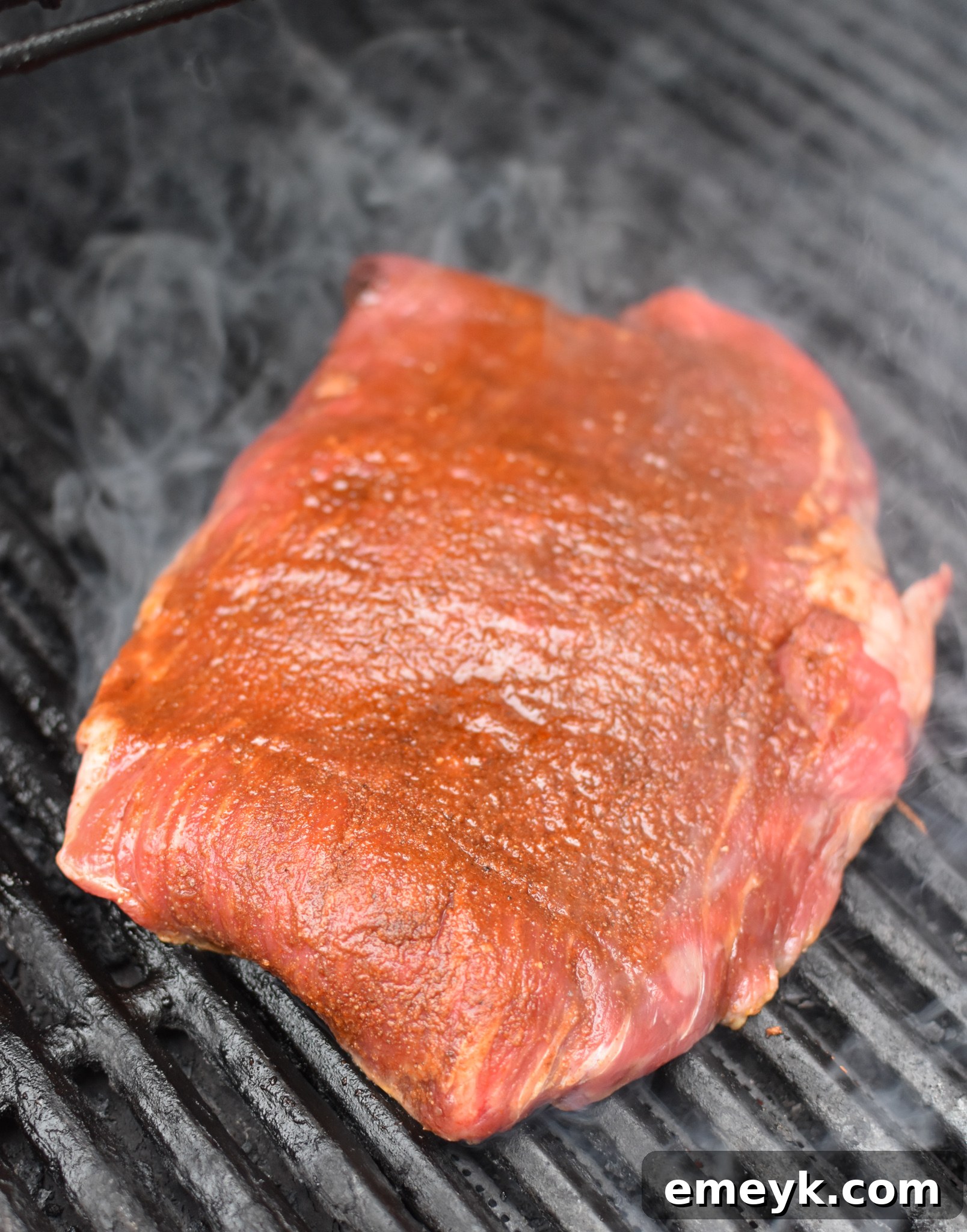 Fire-Kissed Carne Asada 4 Grilled Flank Steak with Dry Rub on grill.