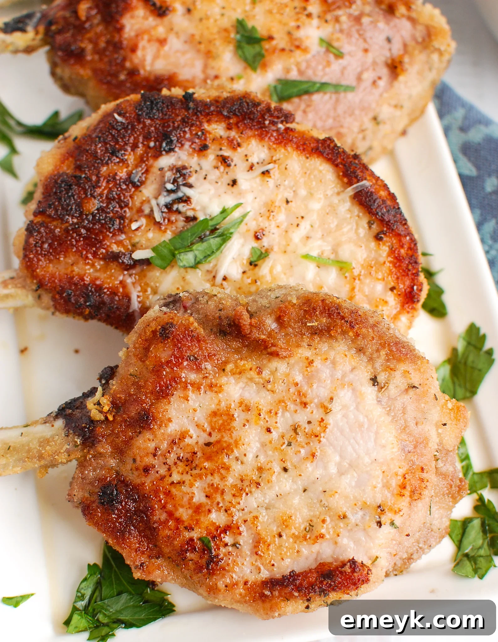 How to Bake Juicy Pork Chops in the Oven on white platter.
