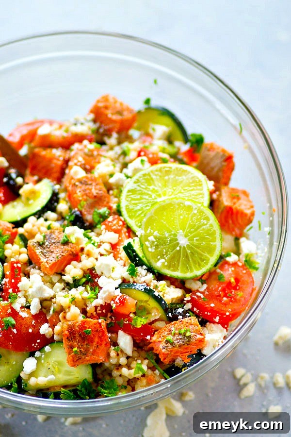 Greek Seared Salmon Couscous Salad featuring flaky salmon, fluffy couscous, and Mediterranean vegetables in a bowl.