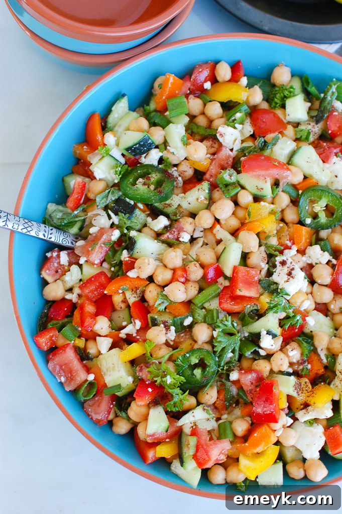 Hearty and flavorful Mediterranean Chickpea Salad with various chopped vegetables and fresh herbs in a bowl.