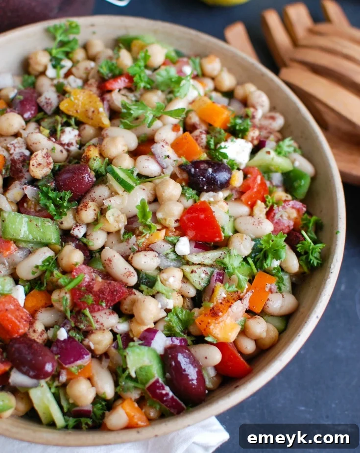 Hearty Mediterranean Bean Salad with mixed beans, corn, red onion, bell peppers, and fresh herbs, dressed in a lemon vinaigrette.