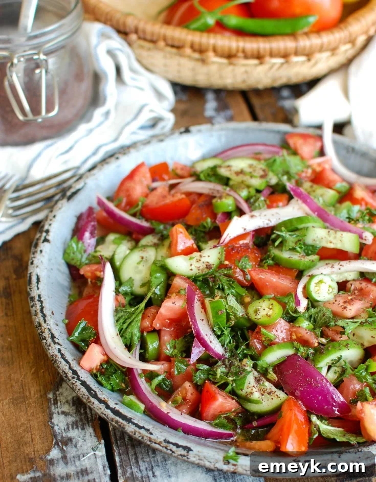 Simple and refreshing Persian Tomato Cucumber Salad with finely diced tomatoes, cucumbers, and red onion, garnished with fresh herbs.
