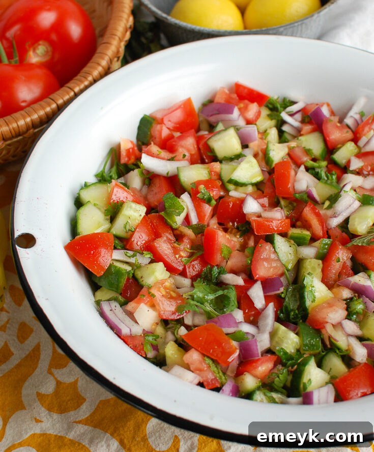 Fresh Israeli Salad with finely chopped cucumbers, tomatoes, red onion, and fresh herbs, typically served with a light lemon-olive oil dressing.