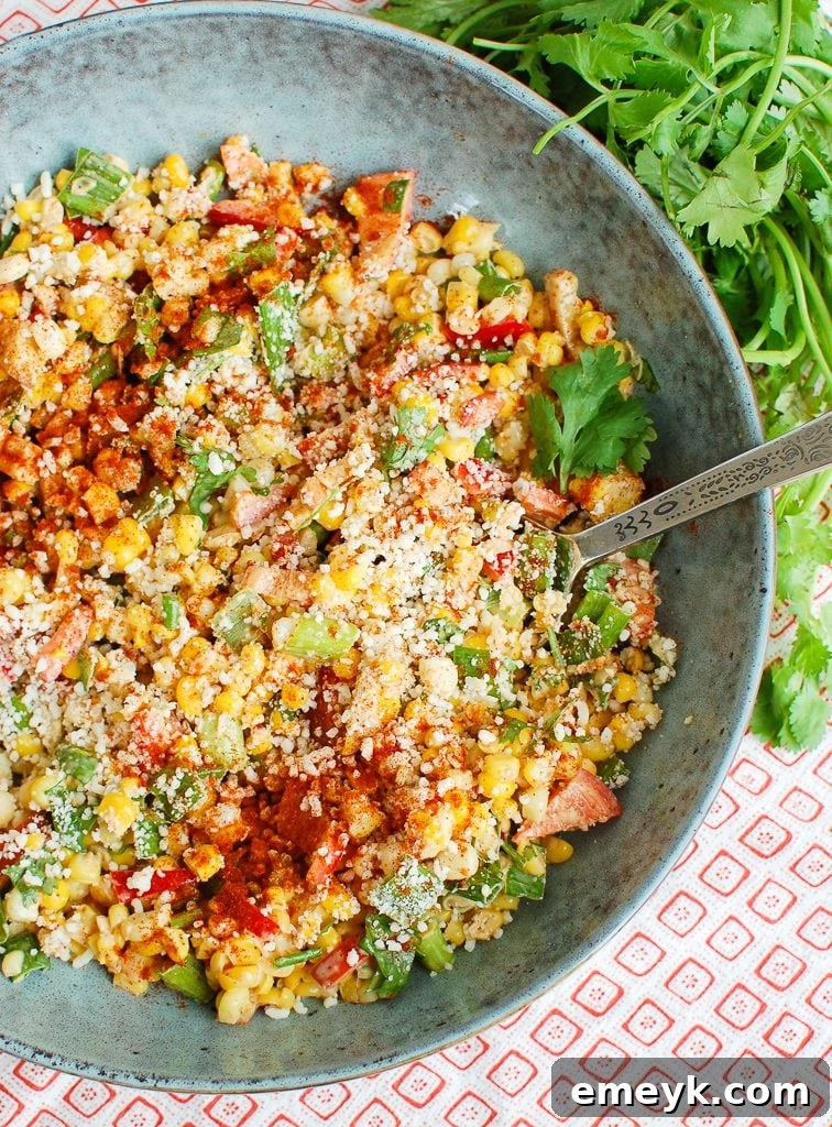Mexican Corn Salad with cheese and a spoon