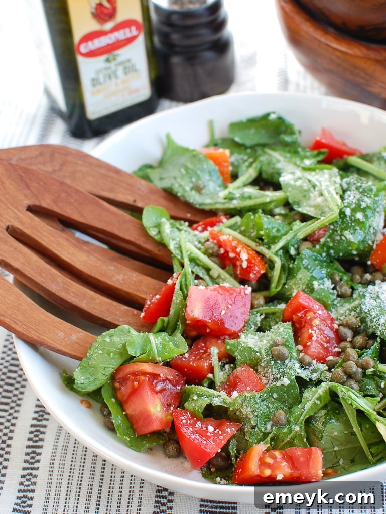 Arugula Salad with Capers with wooden serving spoons 