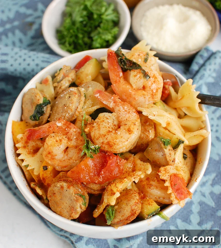 Bayou Blast Pasta with Chicken Sausage and Shrimp 3 A close-up shot of creamy Cajun pasta with chicken sausage, shrimp, and colorful vegetables in a rustic bowl.