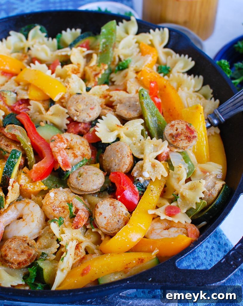 Bayou Blast Pasta with Chicken Sausage and Shrimp 5 A serving of Cajun Pasta with Chicken Sausage and Shrimp on a white plate with a fork, ready to eat.