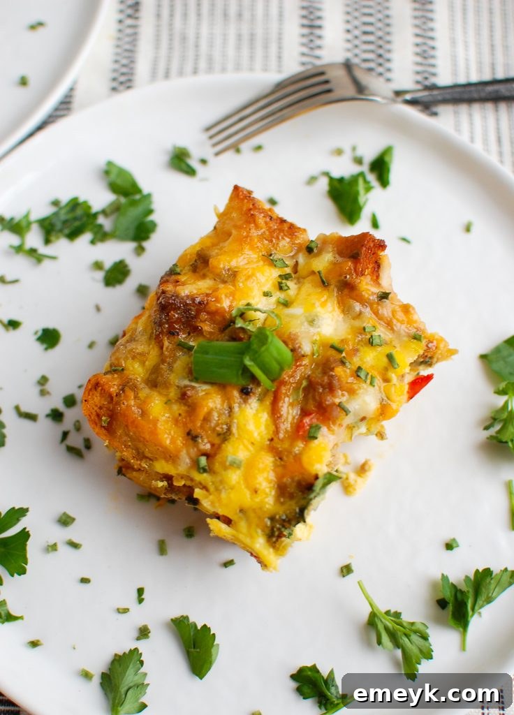 Egg Sausage Casserole garnished with fresh green onion, showcasing its delicious layers.