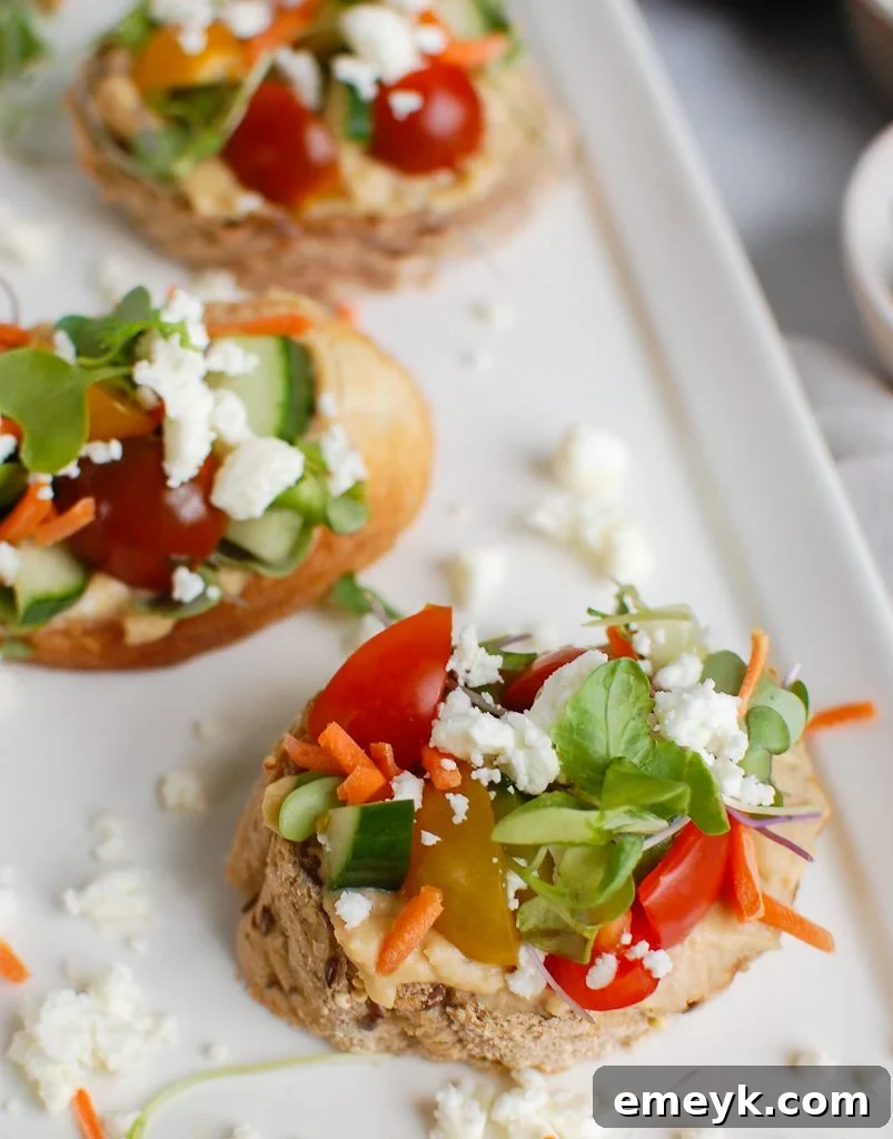 Close-up of Mediterranean Crostini with vibrant diced tomatoes and fresh herbs as toppings.