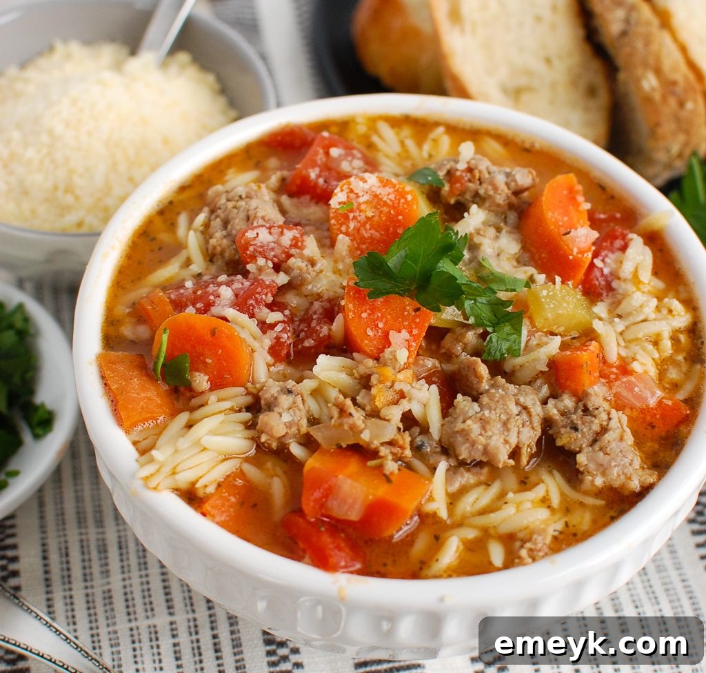 A bowl of Italian Sausage Soup served with a side of crusty bread, perfect for a cozy meal.