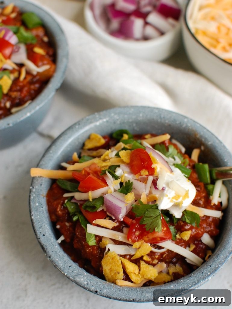 Classic Beef Chili topped with shredded cheese and a dollop of sour cream, ready to serve.