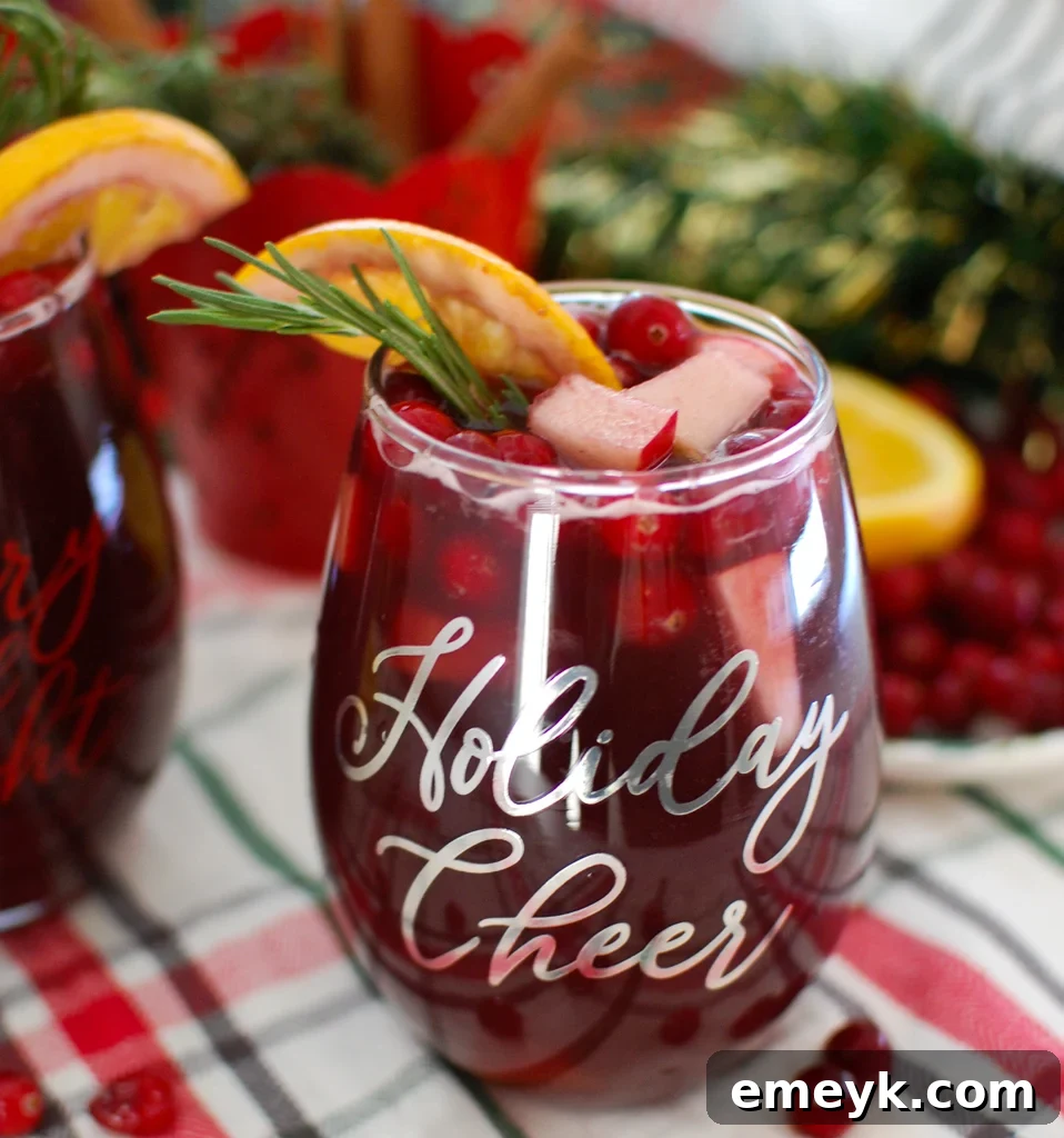 Festive Christmas Sangria garnished with fresh rosemary and cranberries, ready for holiday serving
