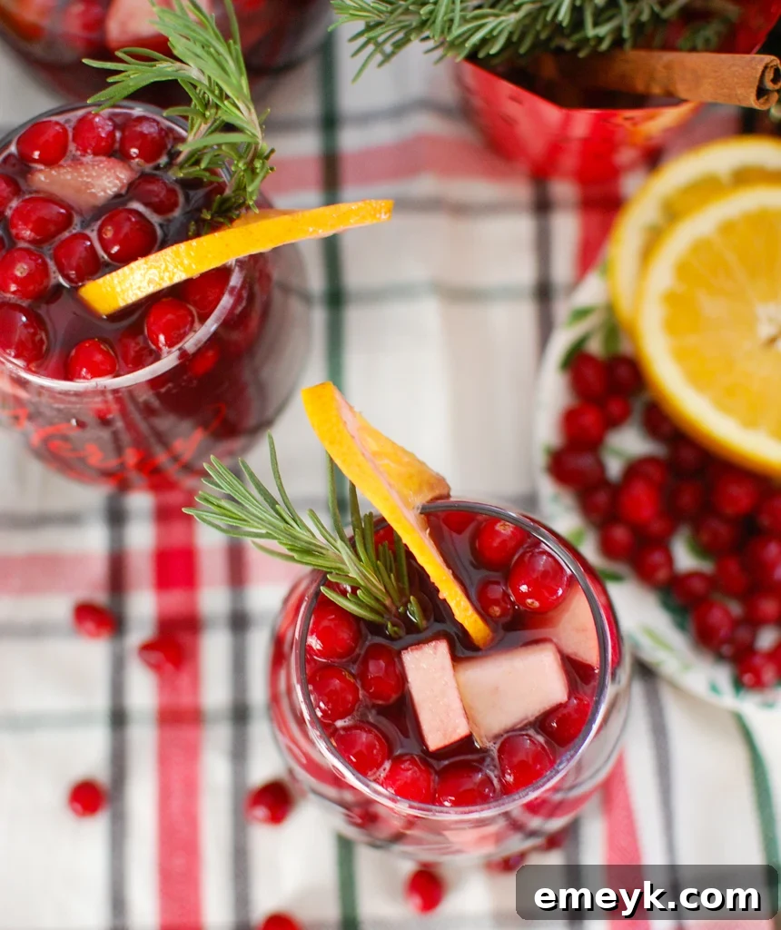 Christmas Sangria in a pitcher with fresh cranberries and fruit slices
