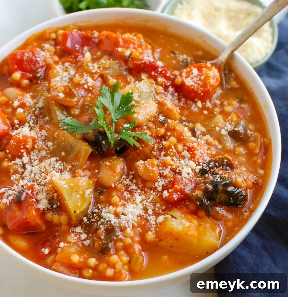 Vegetable Soup with Cabbage in white bowl, garnished with fresh herbs
