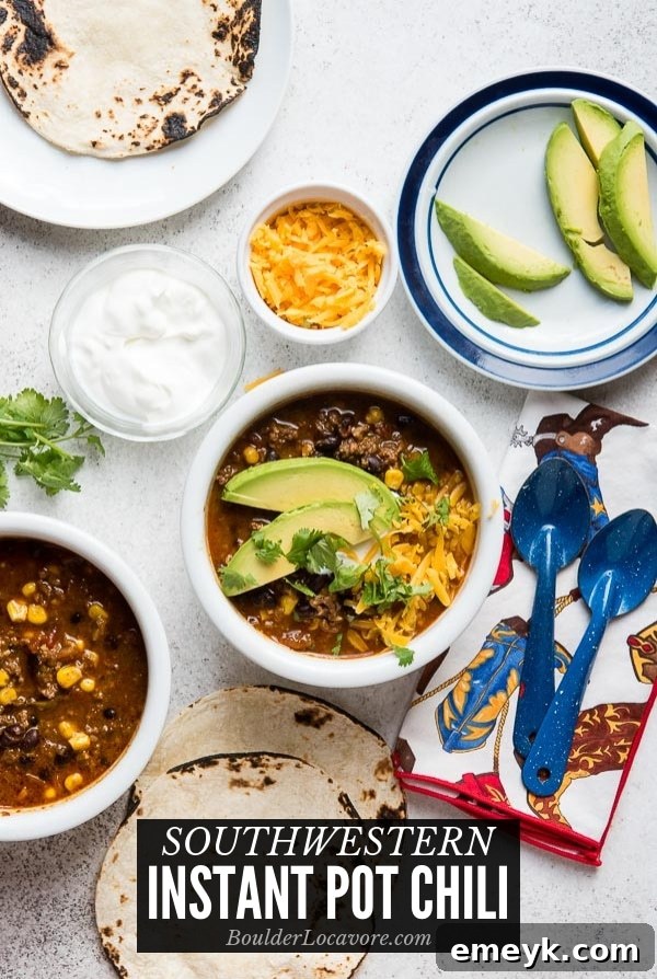 Hearty Southwest Instant Pot Chili garnished with sour cream, shredded cheese, and green onions