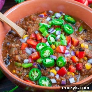 Hearty Vegan Lentil Chili in a bowl, rich with vegetables and topped with fresh herbs