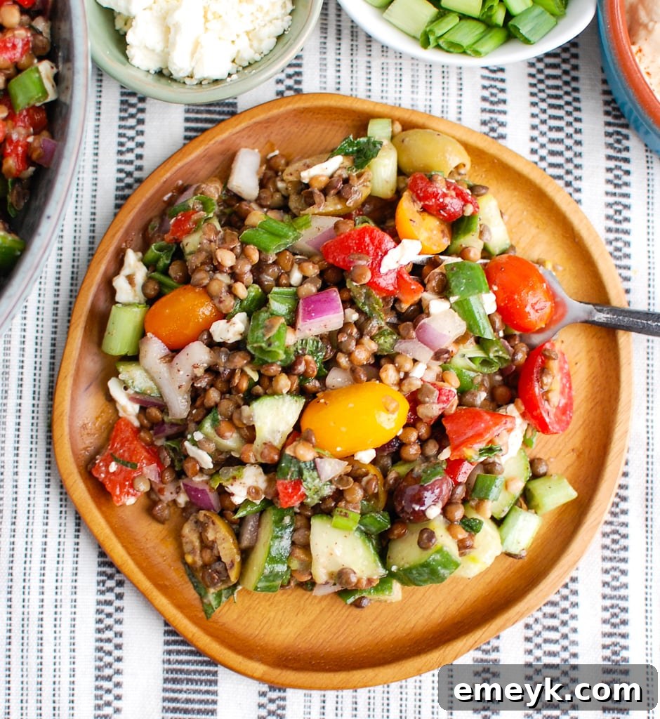 Mediterranean Lentil Salad on a wooden plate with a fork