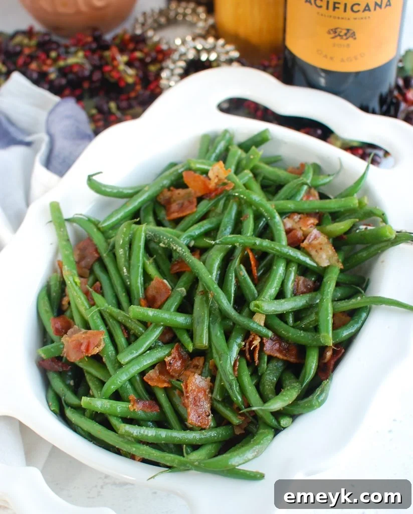 Green Beans with Bacon in a white serving dish, garnished with fresh herbs.
