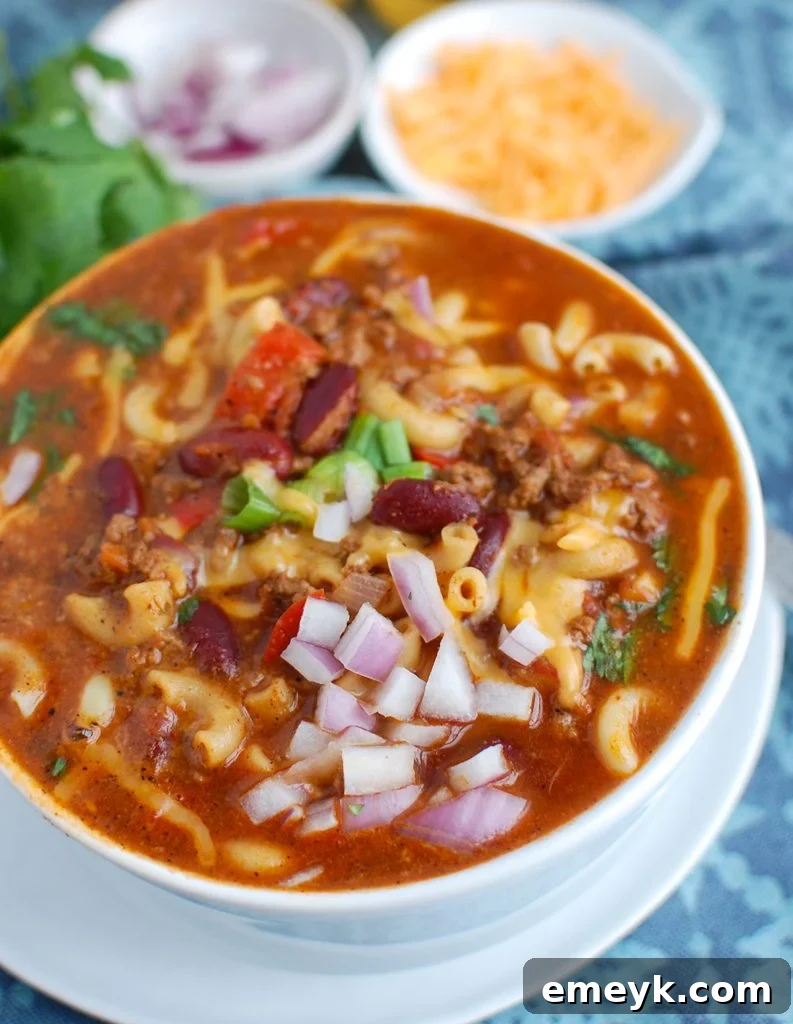 Instant Pot Chili Mac in a white bowl, garnished with fresh herbs