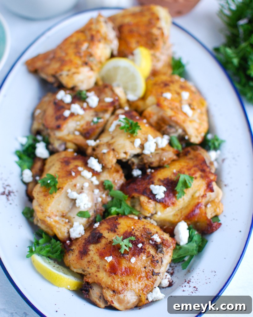 A vibrant platter of Mediterranean Chicken, garnished with fresh herbs and lemon wedges, ready to serve.