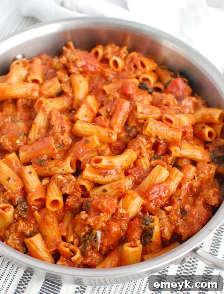 Italian Sausage Pasta simmering in a large pot, ready to be served.