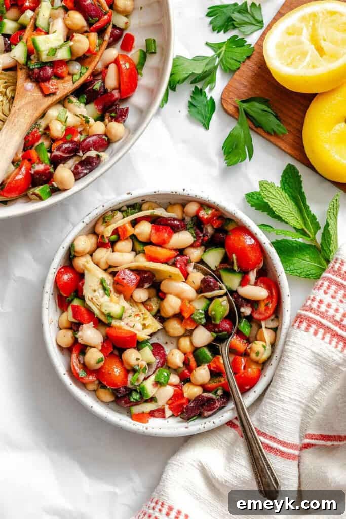Mediterranean Three Bean Salad in bowl with serving spoon, ready to enjoy