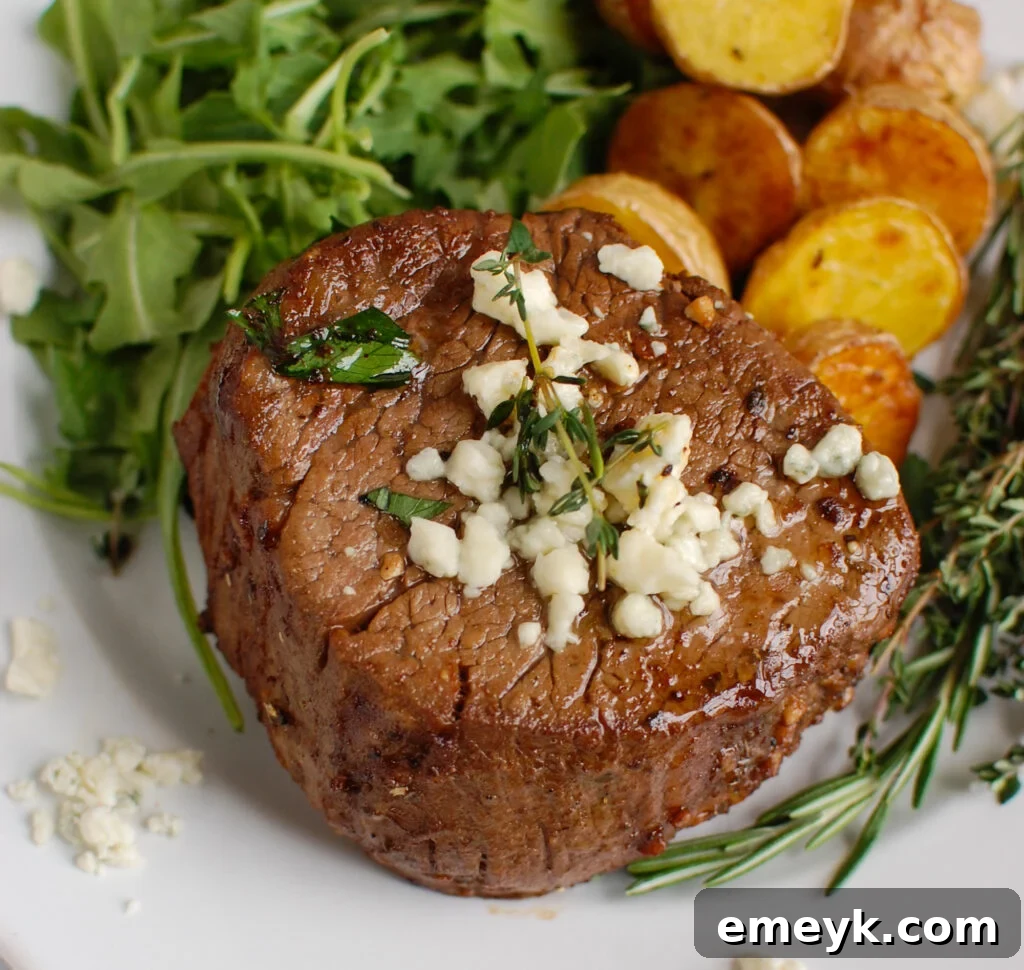 Perfectly cooked Beef Tenderloin Steaks with Creamy Blue Cheese Sauce, garnished with fresh rosemary.