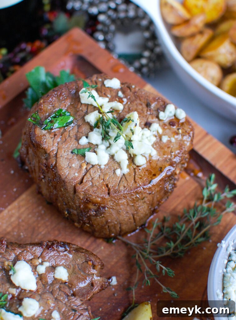 Cooked Beef Tenderloin Steaks with Blue Cheese Sauce resting on a wooden cutting board.