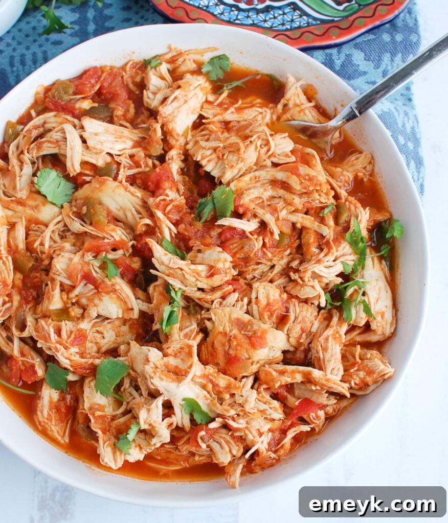 Effortless Instant Pot Shredded Chicken 5 Easy Instant Pot Shredded Chicken being stirred with a spoon in the Instant Pot liner