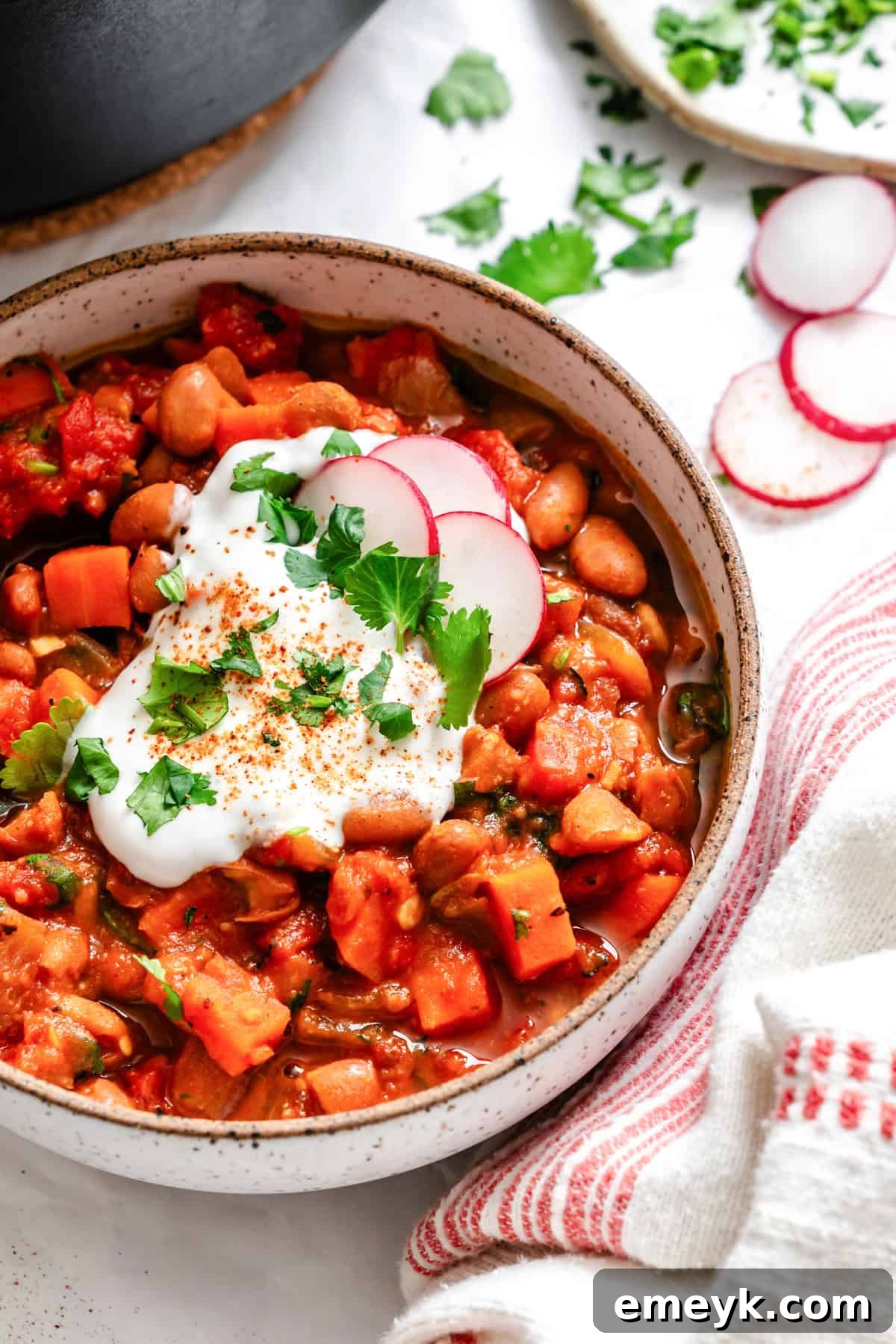 Hearty Homemade Vegetarian Chili served in a white bowl with fresh garnishes