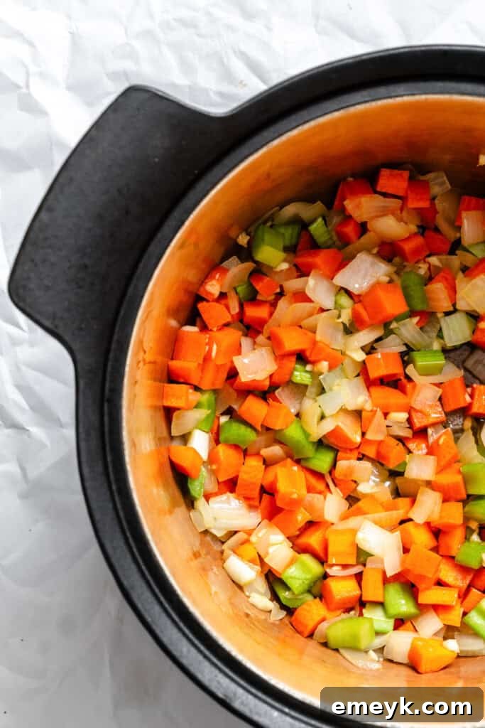 Carrots and onions sauteeing together in a pot for chili