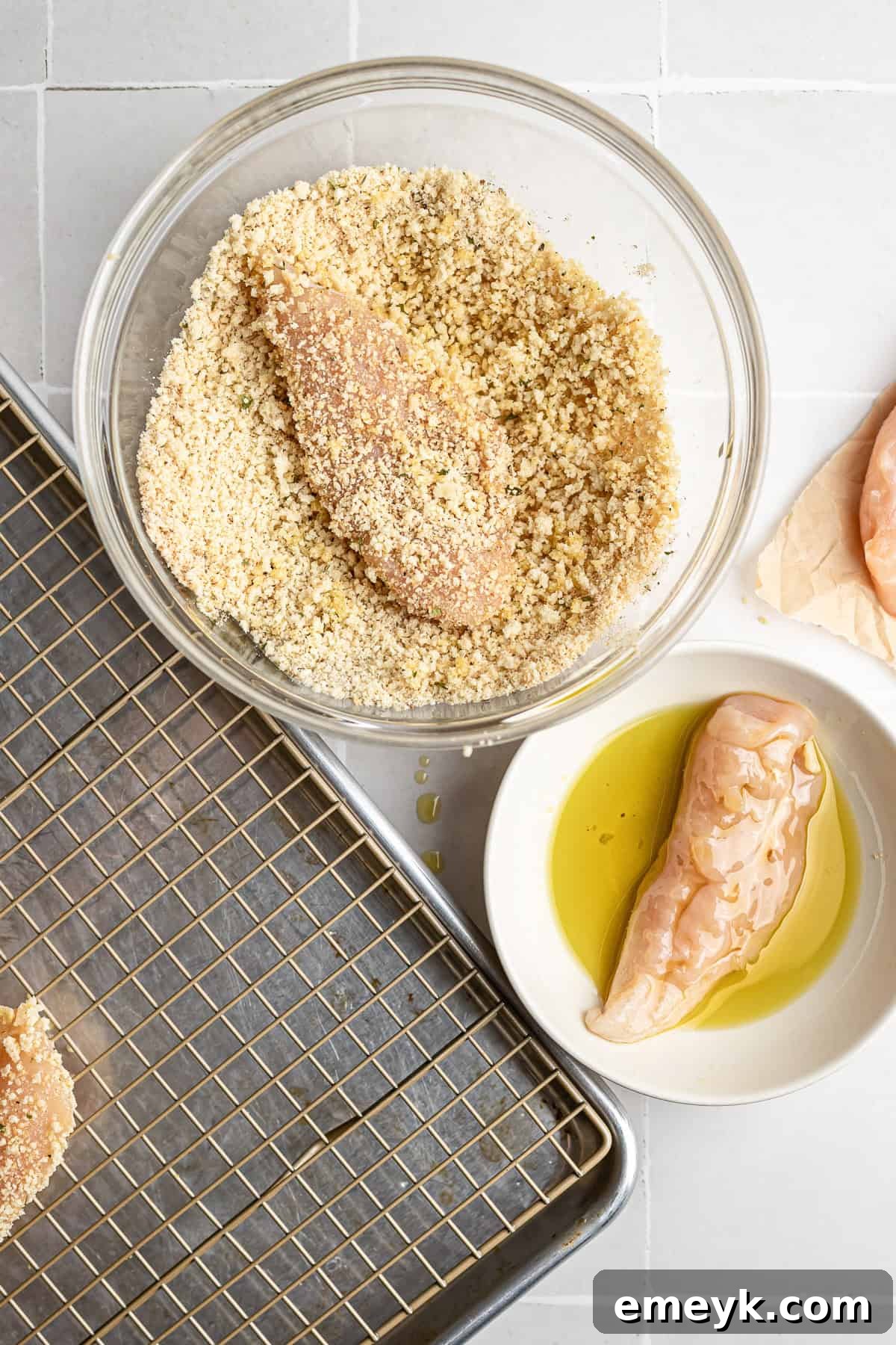 Perfectly Crispy Baked Chicken Tenders 5 step 2 – dredging chicken tenders in olive oil before coating